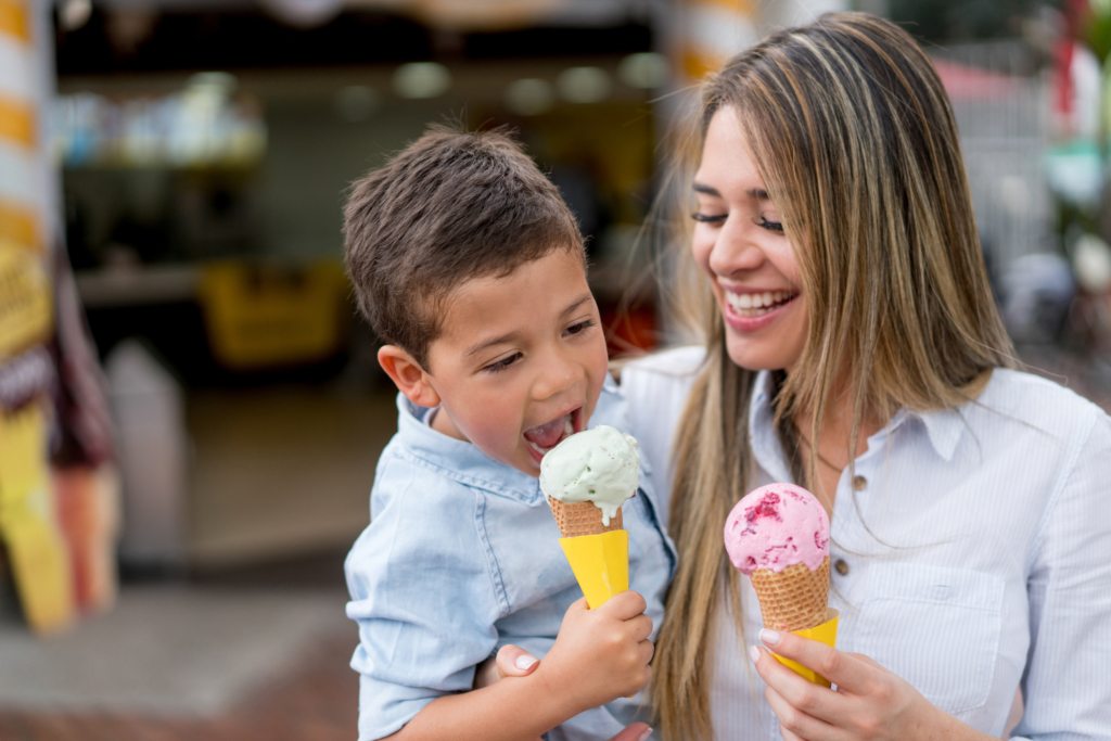 Woman and child smiling eating ice cream cones