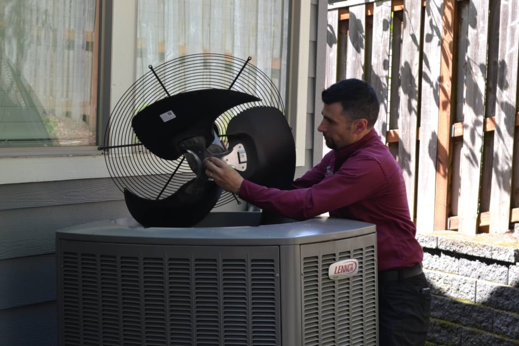 Portland AC installation technician from Central Air installing an AC fan.