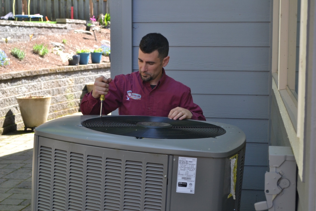 HVAC technician servicing a heating system for winter in Portland home.