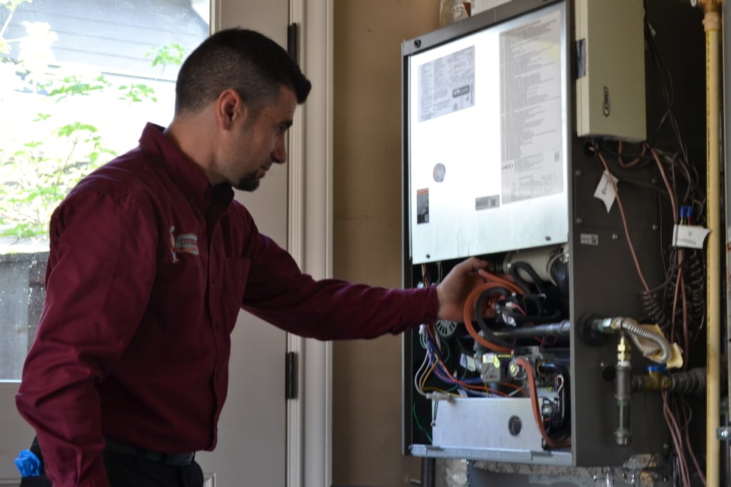 Technician servicing a furnace in a Portland home.