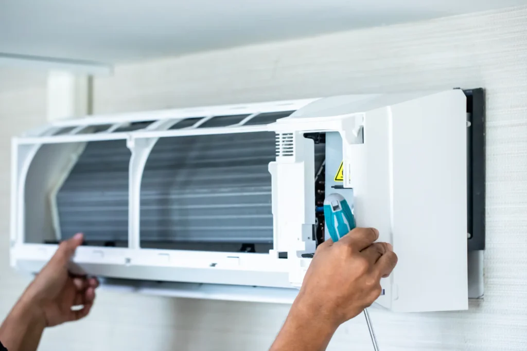 Technician inspecting AC loud noise for repair in Portland home.