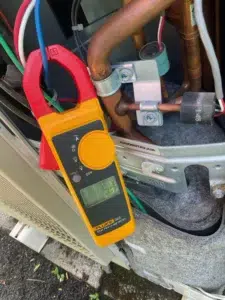 Technician replacing a mini-split condensate pump during cooling maintenance in Beaverton OR