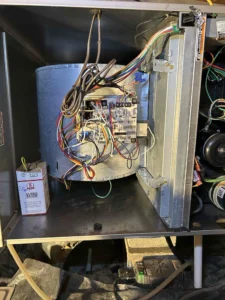 Technician servicing furnace blower motor and cleaning internal heating components in Portland, OR.