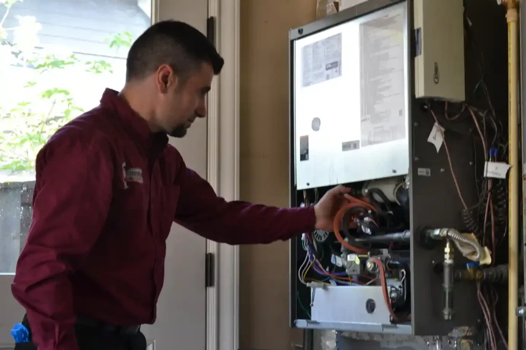 Technician diagnosing furnace components during a Portland heating repair service.