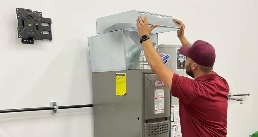 Technician inspecting a furnace and ductwork in Portland to address heating system startup and shutdown issues.